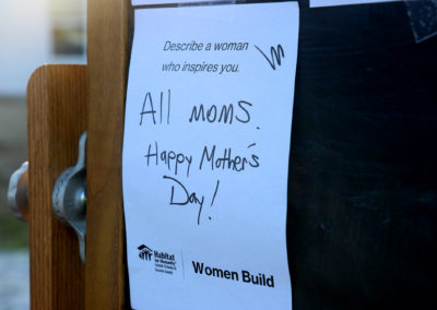 Close-up of handwritten paper on chalkboard reading "Describe a women who inspires you: All moms. Happy Mother's Day!"