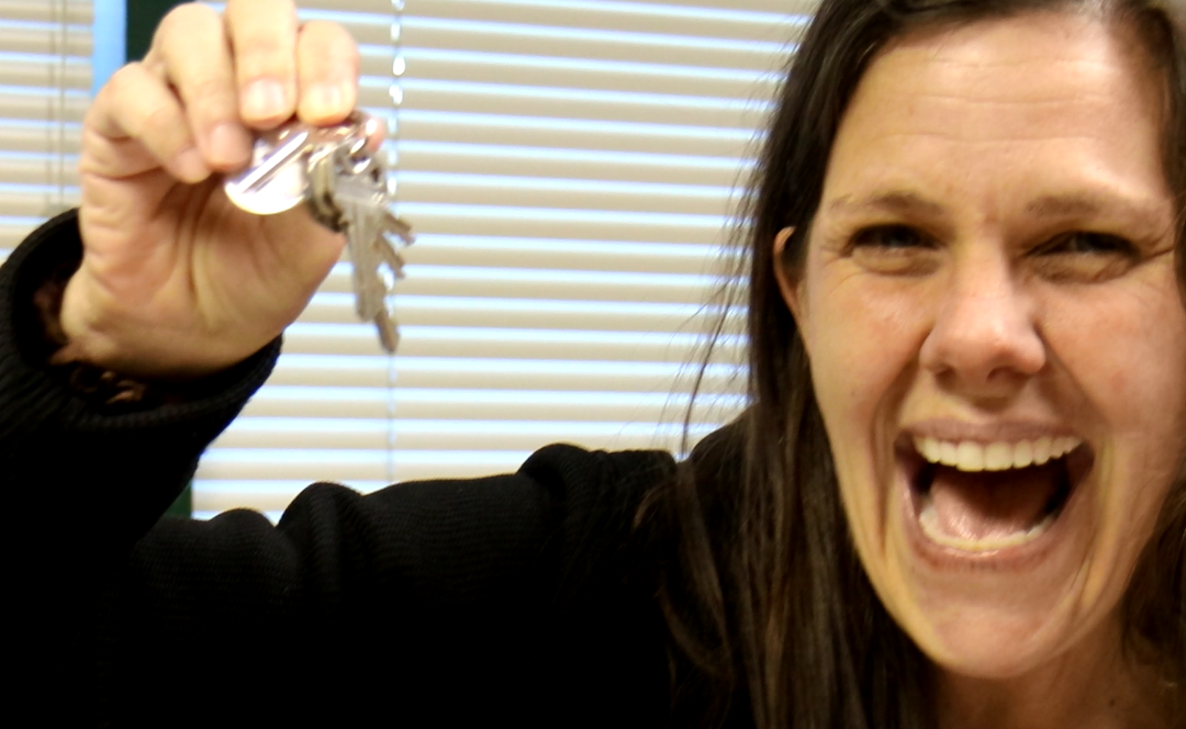 woman smiling and holding up keys