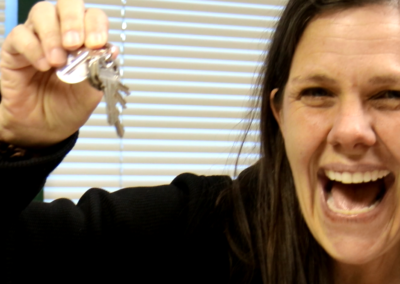 woman smiling and holding up keys