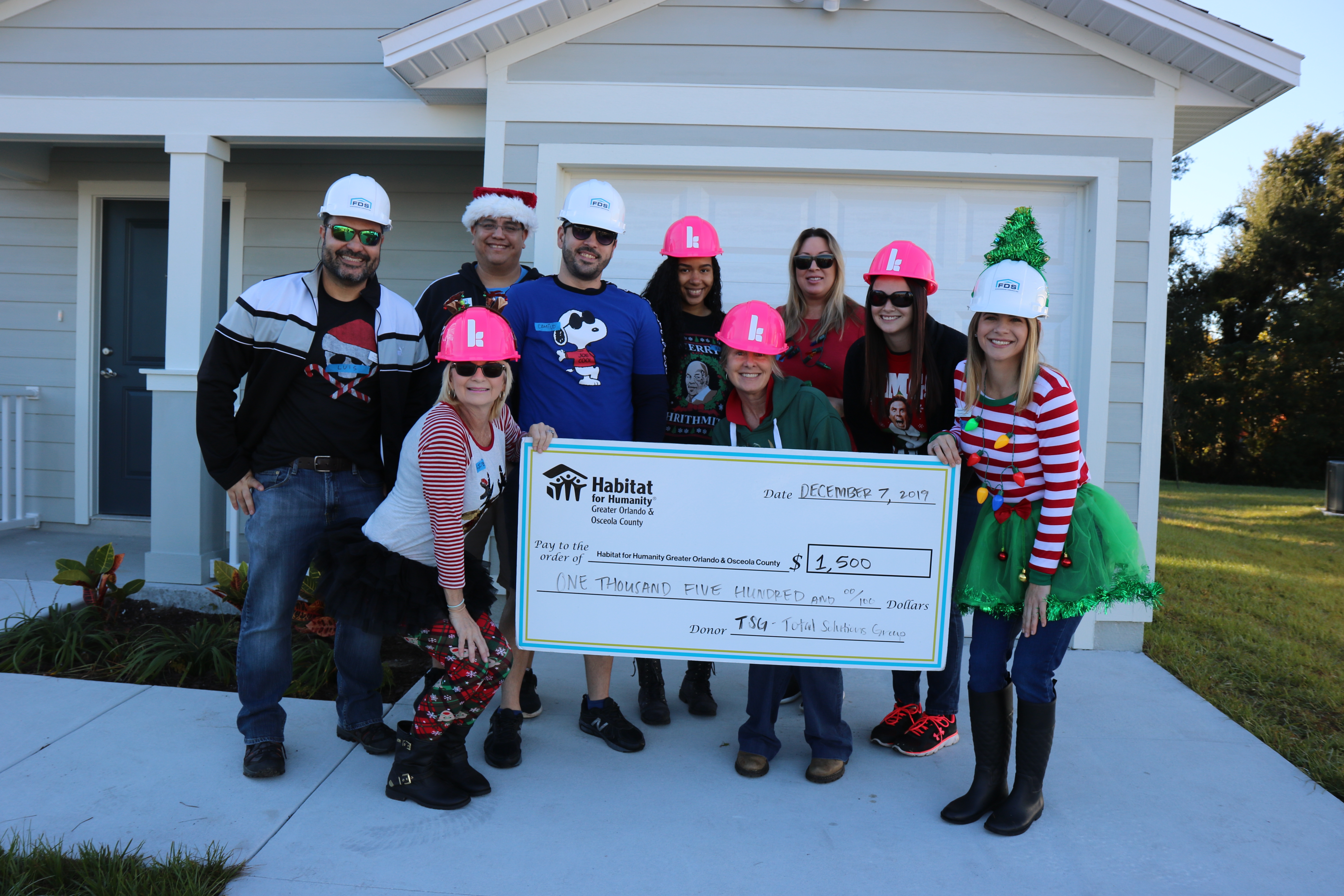 Holiday Build volunteers pose with their donation
